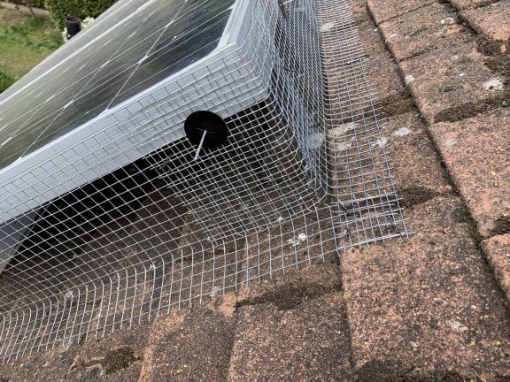 Mesh fitted round a corner with the use of a solar panel clip.